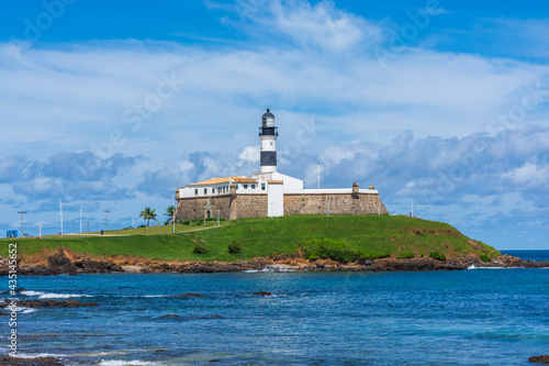 The historic architecture of Salvador in Bahia, Brazil showcasing the Farol da Barra Lighthouse at Bahia de Todos os Santos Bay on a sunny summer day