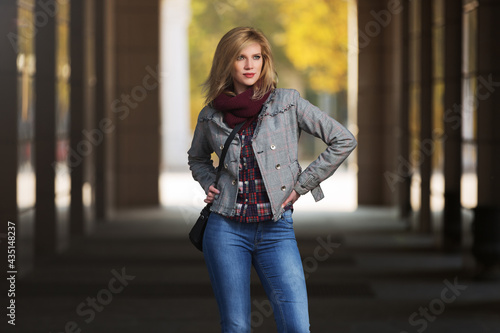 Young fashion blonde woman in checked plaid blazer and snood scarf