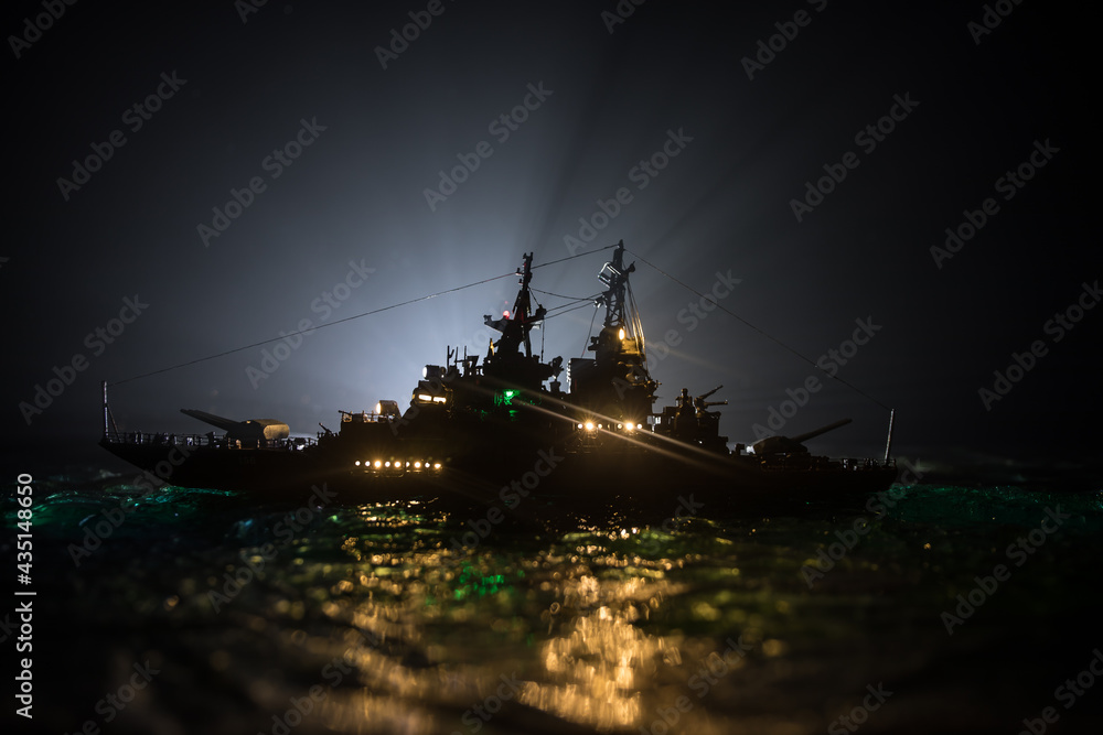 Fototapeta premium Silhouettes of a crowd standing at blurred military war ship on foggy background. Selective focus.