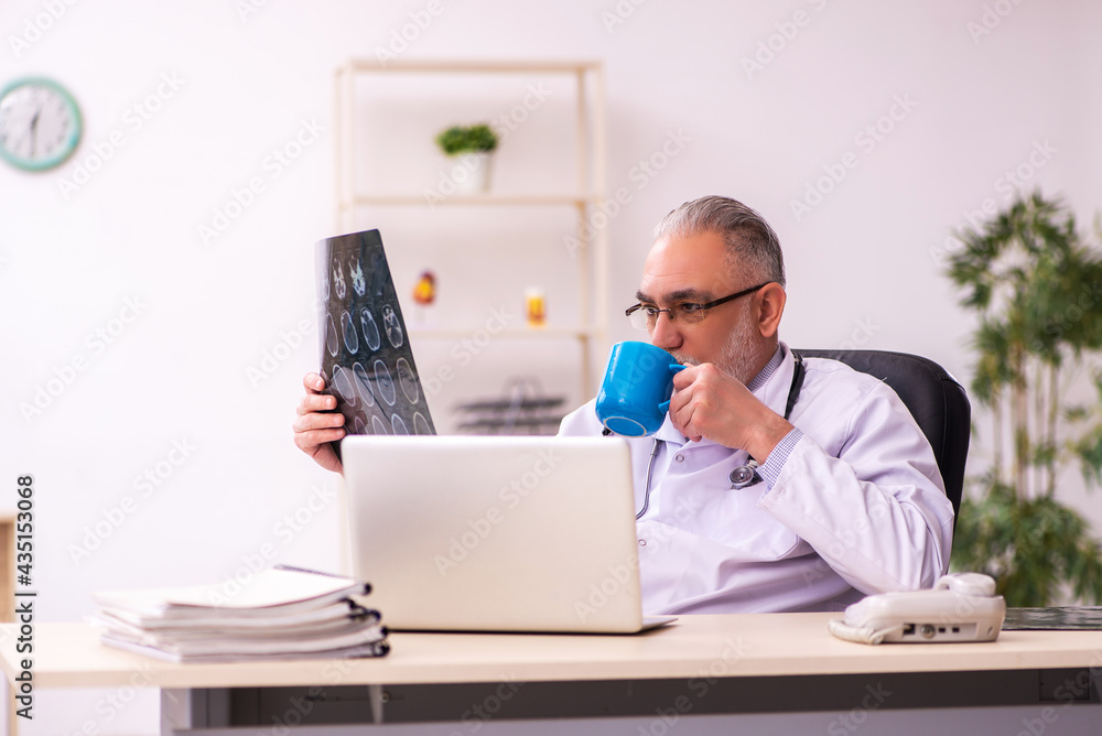 Aged male doctor radiologist working in the clinic Aged male doctor radiologist working in the clinic