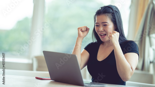 woman showing joy while working in front of the labtop