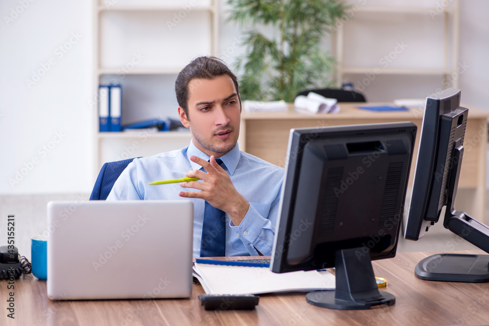 Young male employee working in the office Young male employee working in the office