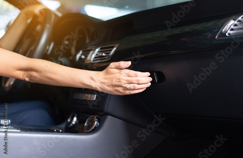 Hand driver open glove compartment box in car for searching object
