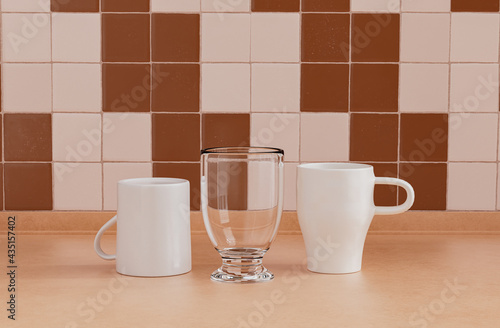 2 coffee mugs and single water glass side by side on kitchen countertop with wall, close up front view, 3d rendering, no people