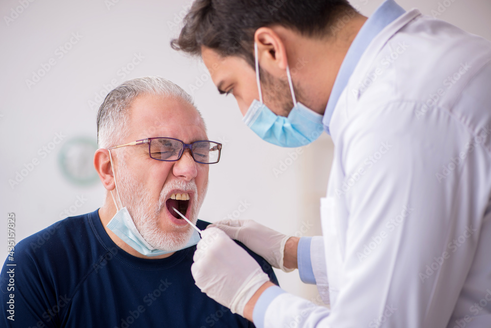 Fototapeta premium Old male patient visiting young male doctor otorhinolaryngologis