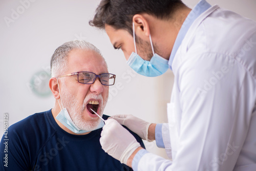 Old male patient visiting young male doctor otorhinolaryngologis