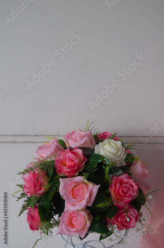 Artificial pink white roses bouquet with leaves.