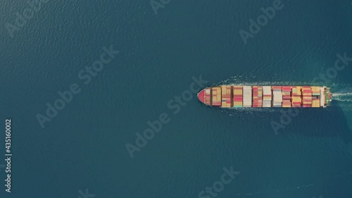 Aerial top view large cargo vessel ships under drone.Freight ship full of containers.Huge marine craft shipping import export cargo.Concept of sea transport logistics carriage.High quality 4k footage