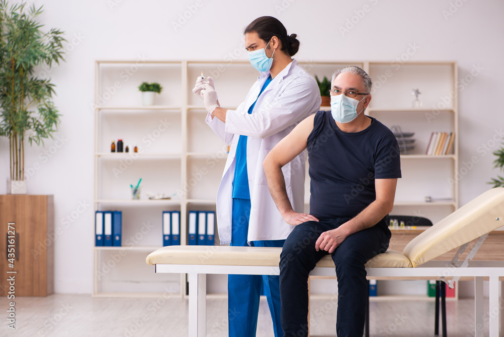 Old man visiting young doctor in covid-19 vaccination concept Old man visiting young doctor in covid-19 vaccination concept