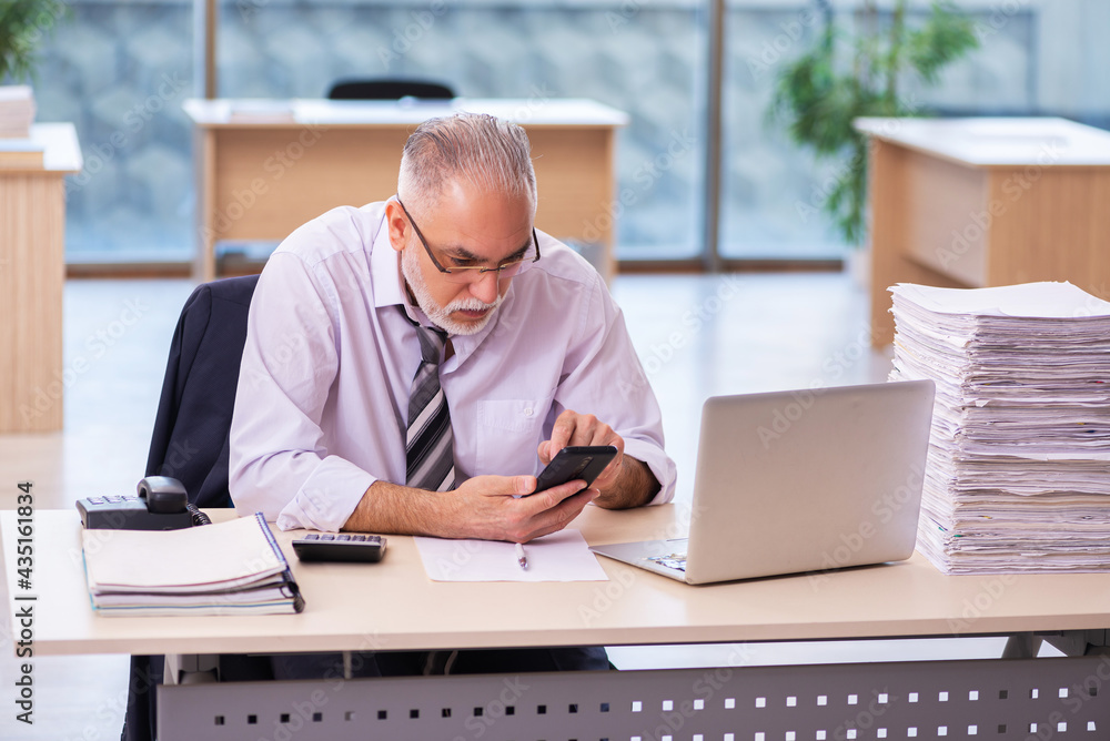 Aged businessman employee unhappy with excessive work Aged businessman employee unhappy with excessive work