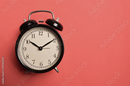 Top view of alarm clock on red background with copy space.