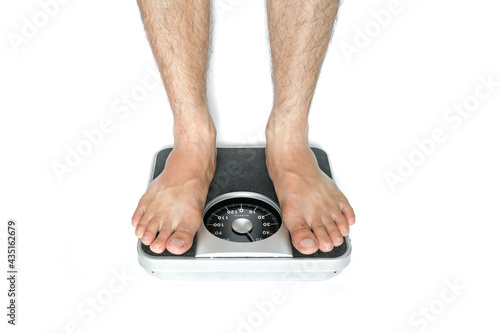Legs of men standing on scales weight background fitness room on white background . Concept of healthy lifestyle and sport