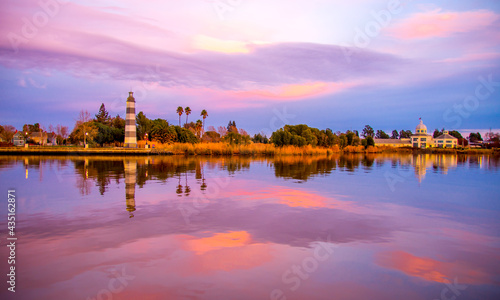 lighthouse at sunset, blue pink magnificent nature sky reflection on the water