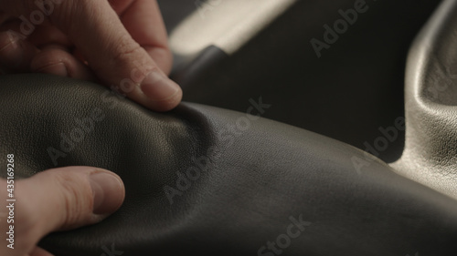 Man hand touching soft leather with sun shining from a window