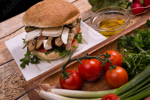 Burger with fried sardinas and feta cheese photo