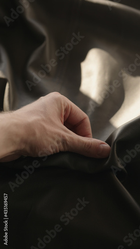 Man hand touching soft leather with sun shining from a window