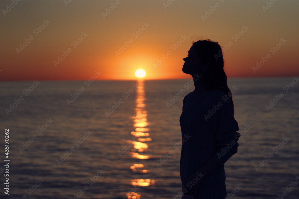 woman at sunset near the sea with a camera in hand
