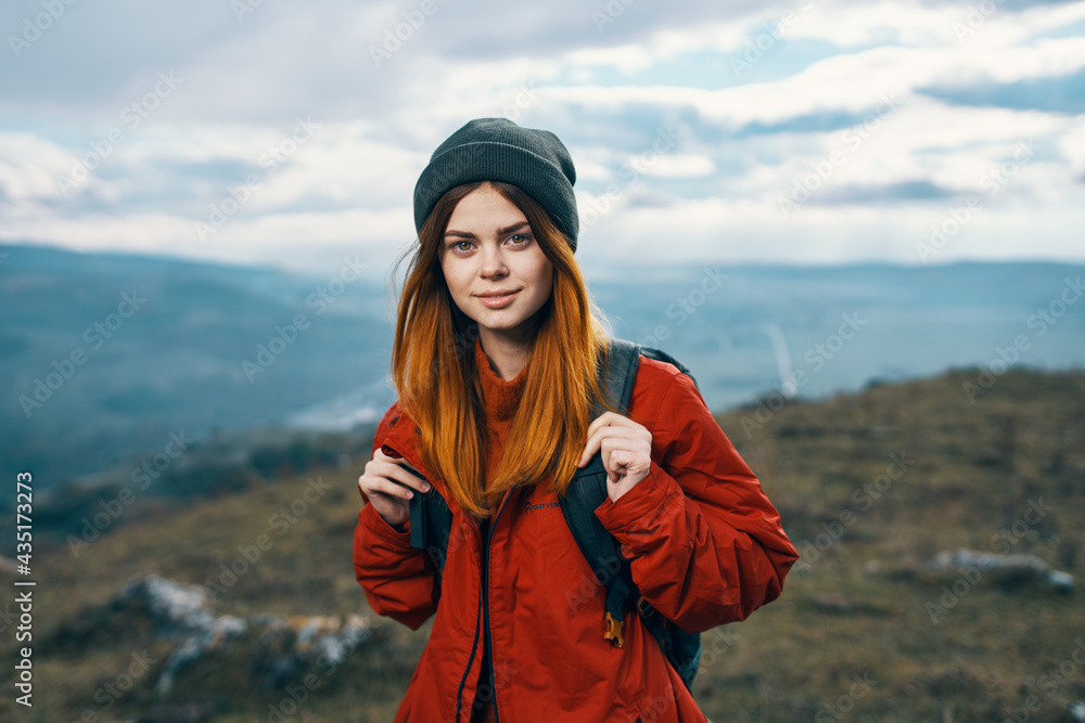 young traveler with backpack and mountains in the background landscape sky clouds