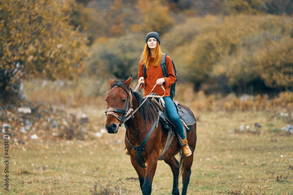 woman hiker rides a horse in a field mountains nature landscape woman hiker rides a horse in a field mountains nature landscape