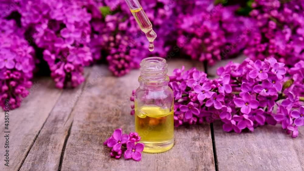 Lilac essential oil and extract in a small bottle. Selective focus. Lilac essential oil and extract in a small bottle. Selective focus.