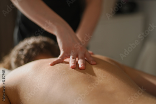 Masseur hands massaging thighs of an attractive woman