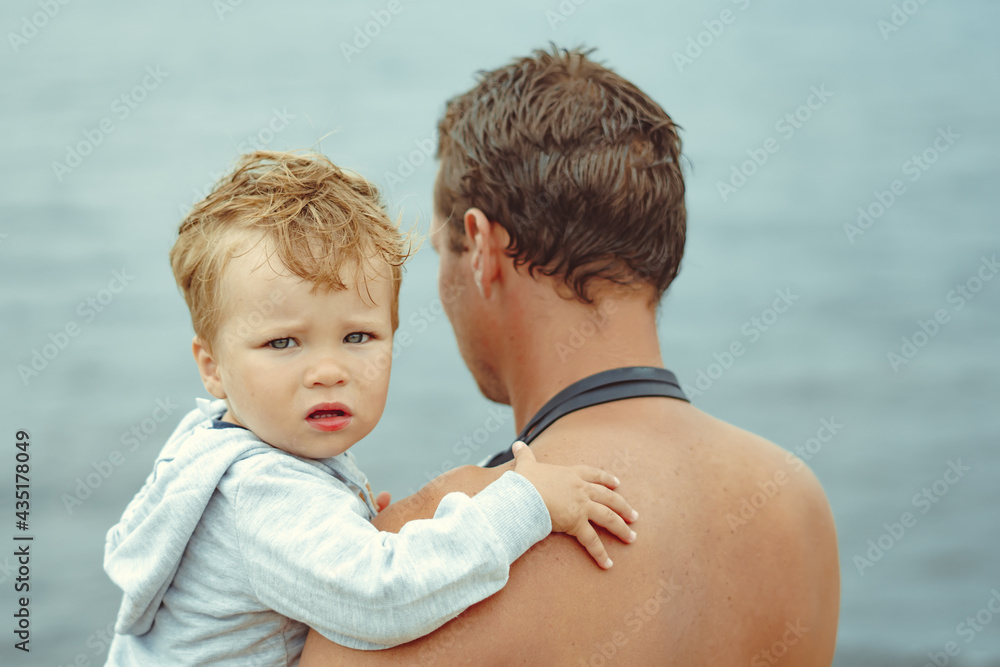 a father holds his son in his arms a father holds his son in his arms