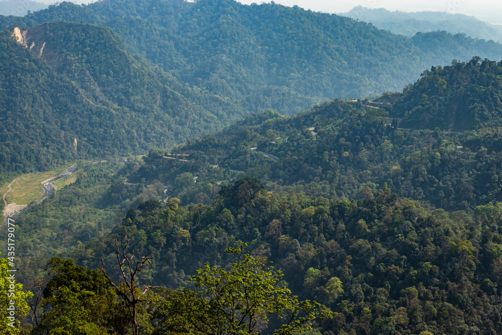 Obraz premium mountain range with dense green forests at morning from flat angle