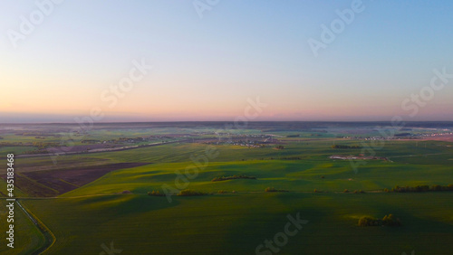 Drone view of the evening landscape at sunset with fields and clouds © Payllik