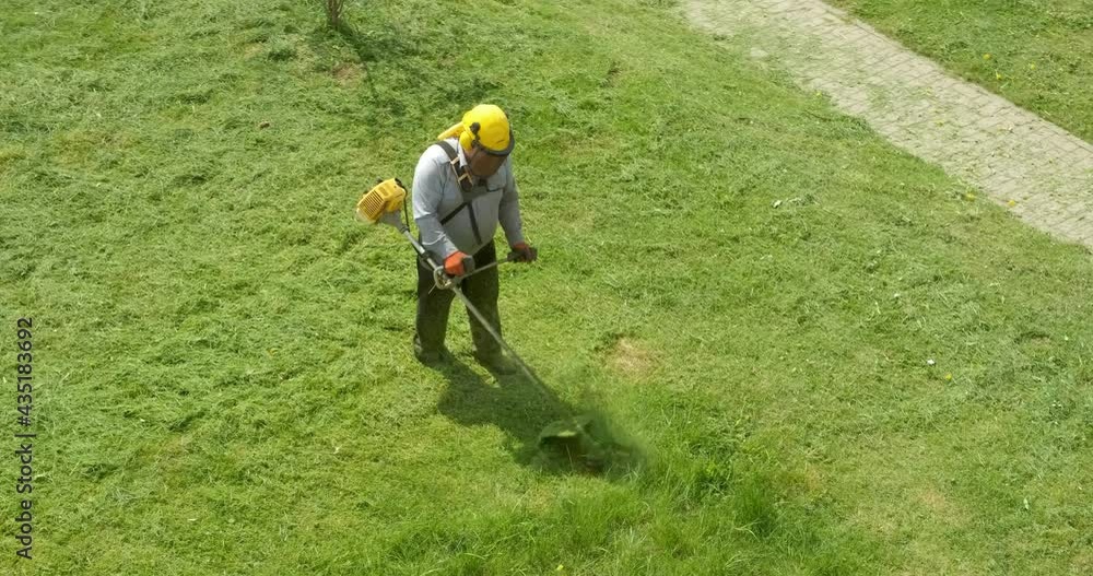 lawnmover man worker cutting dry grass with lawn mower. lawnmover man worker cutting dry grass with lawn mower.