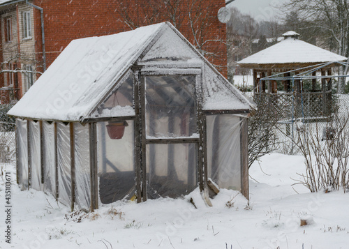 fresh snow covers the surroundings and the greenhouse in the garden, snow-textured surfaces