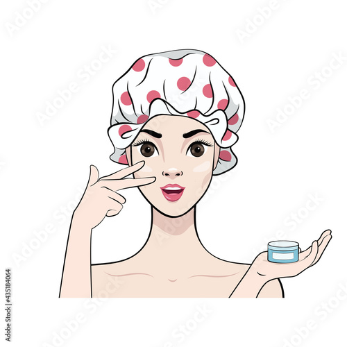 Beautiful girl in a shower cap applies a moisturizing anti-aging cream to her face. Skin care