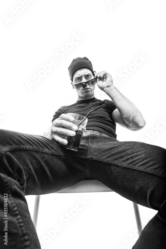 young man sits on a chair with a cocktail