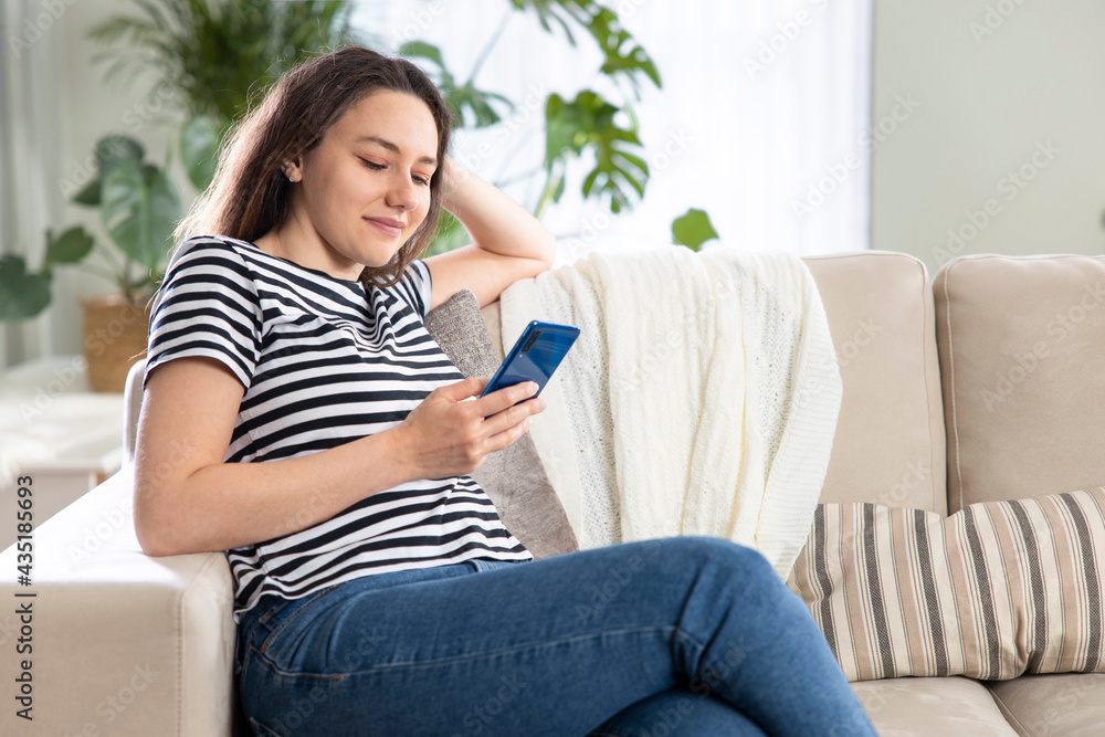 Young woman using phone at home