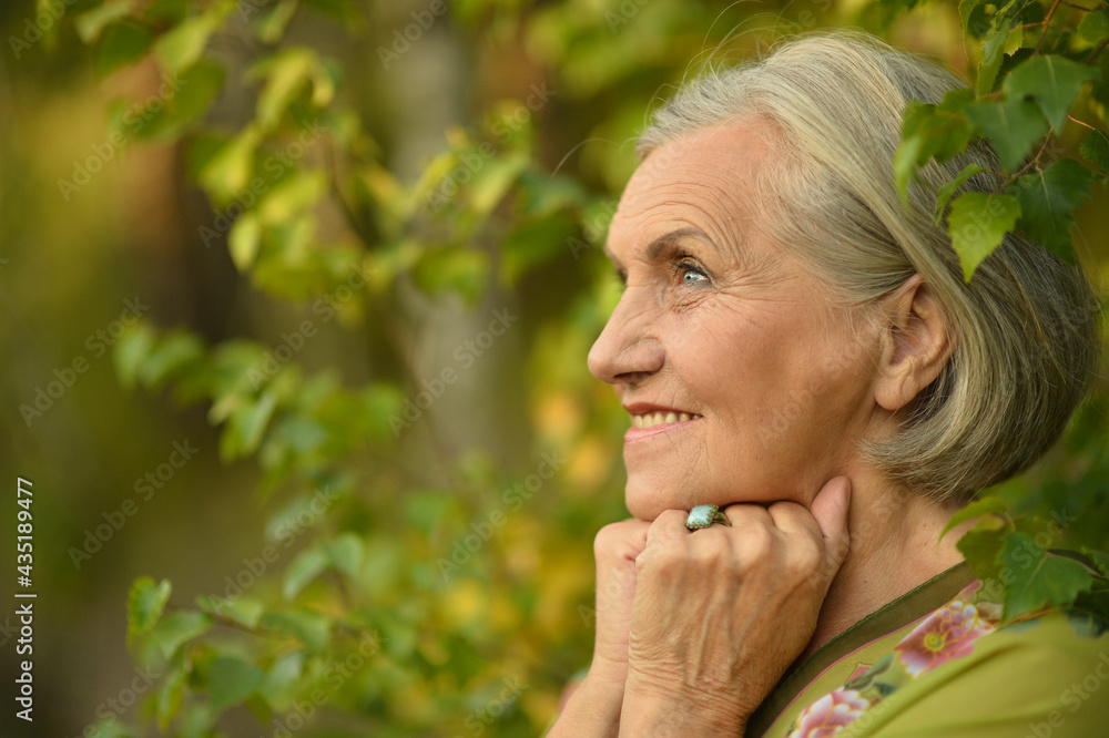 portrait of a happy smiling senior woman in park portrait of a happy smiling senior woman in park