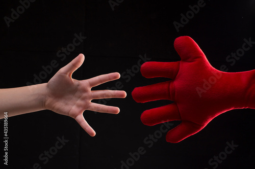 Fotografie Hand reaching out for help, young boy playing with plush soft toy, handshake wit
