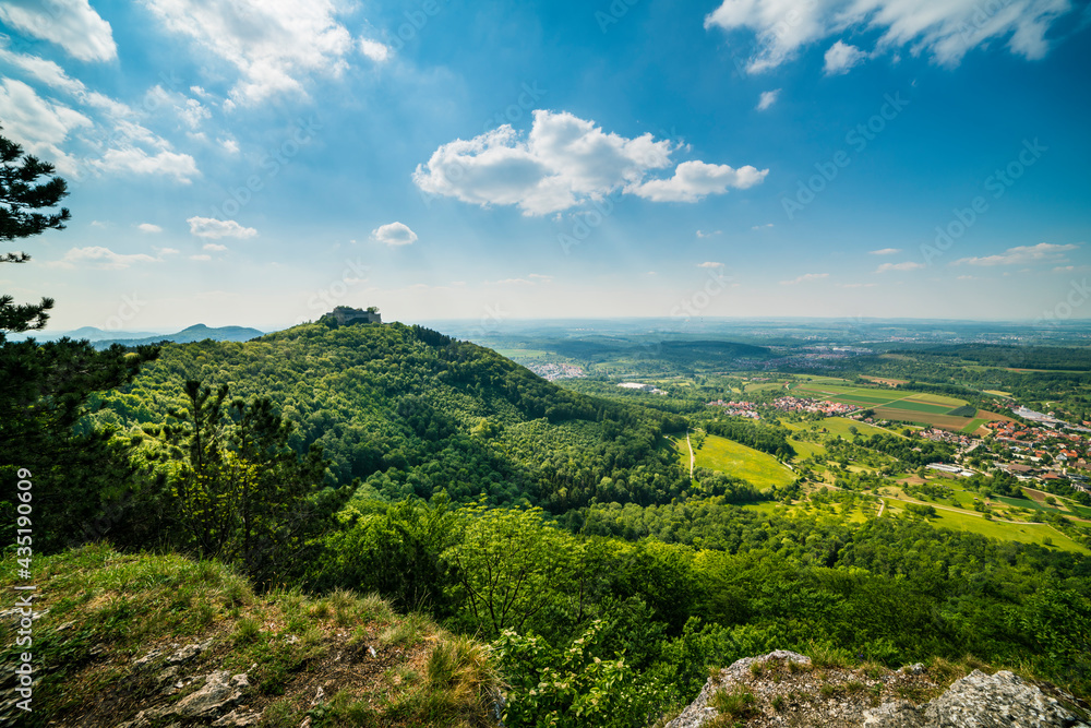 Germany, Hohenneuffen castsle ruins in colorful spring atmosphere on top of a mountain surrounded by endless green nature landscape and villages