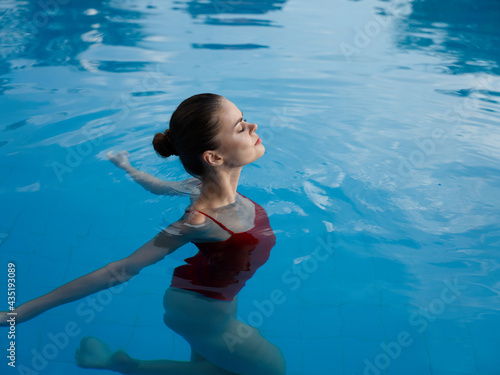 woman in the pool shrug to the sides and red swimsuit vacation relax