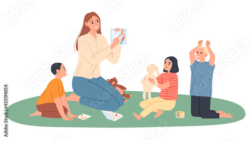 Kindergarten teacher plays with children, she shows them pictures with letters.