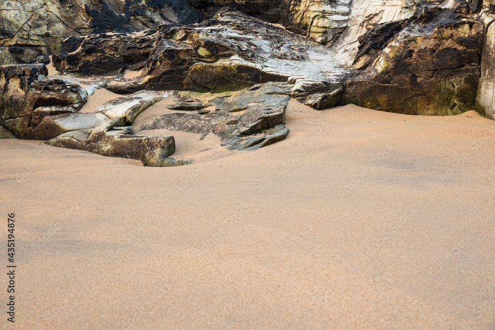 Obraz premium Unusual landscape image giving an abstract look of small scale rocks in beach as large cliffs and plains with lovely sand texture