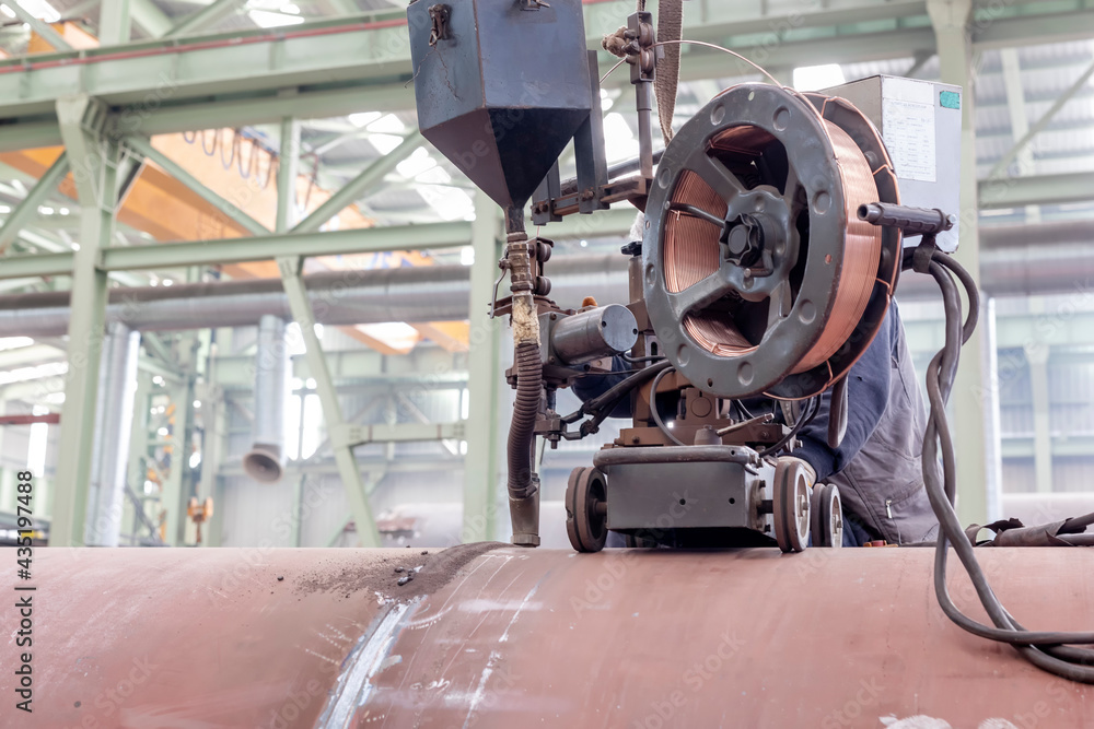Welder operator is welding to pipe with submerged arc welding (SAW