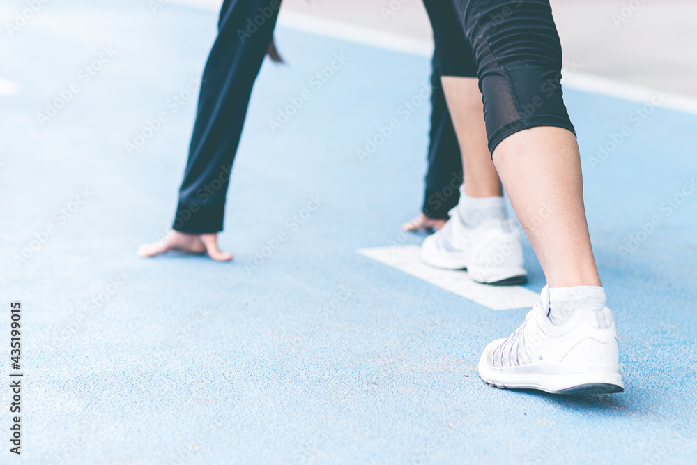 Close up selective focus Woman foot with sneaker on running track getting ready to start. exercise, fitness, workout, sport, lifestyle concept. Goal of business. Forward to Success concept. Close up selective focus Woman foot with sneaker on running track getting ready to start. exercise, fitness, workout, sport, lifestyle concept. Goal of business. Forward to Success concept.