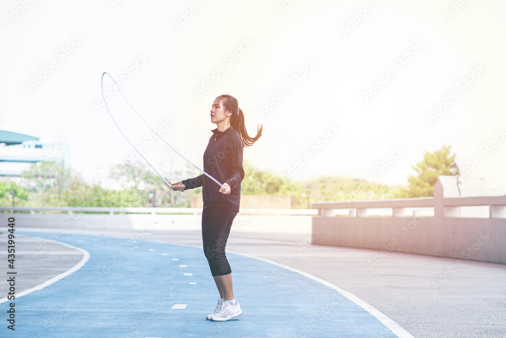 Beautiful sports woman exercises with jumping rope on Running Track. female fitness model exercise or work out. exercise, fitness, workout, sport, lifestyle. Athletic woman training hard concept.