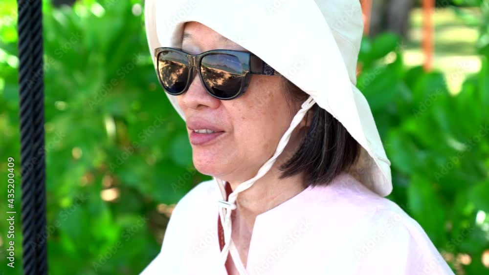 portrait of senior asian woman playing swing in garden on summer vacation portrait of senior asian woman playing swing in garden on summer vacation