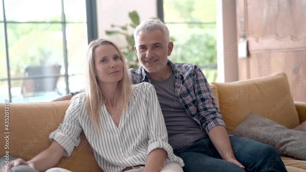 Portrait of middle-aged couple relaxing in sofa at home Portrait of middle-aged couple relaxing in sofa at home