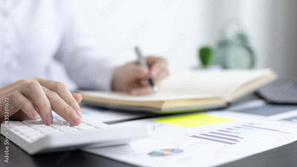 Head of accounting is recording the company's financial growth statistics using graphs as a reference for reviewing and analyzing the results, Taking notes and analyzing data graphs in office. Head of accounting is recording the company's financial growth statistics using graphs as a reference for reviewing and analyzing the results, Taking notes and analyzing data graphs in office.