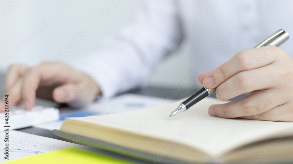 Head of accounting is recording the company's financial growth statistics using graphs as a reference for reviewing and analyzing the results, Taking notes and analyzing data graphs in office. Head of accounting is recording the company's financial growth statistics using graphs as a reference for reviewing and analyzing the results, Taking notes and analyzing data graphs in office.