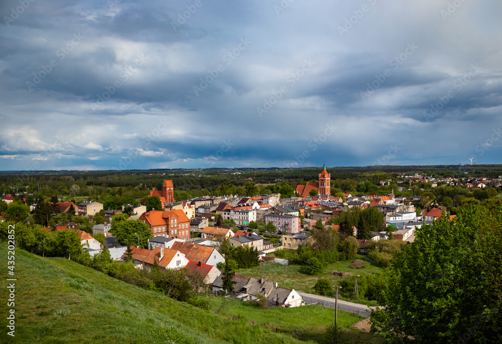 Small old town between forest. Cloudy sky. Beautiful cityscape and landscape. A lot of green lands.