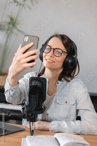 podcaster creates content, European woman records podcast with microphone and headphones, Caucasian woman in recording studio records voice for commercials or audio book, confident woman radio host