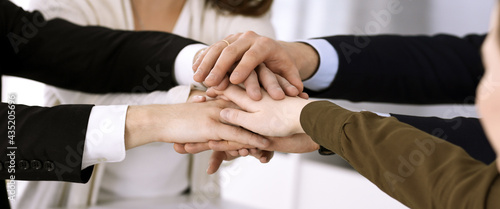 Business people group showing teamwork and joining hands or giving five in modern office. Unknown businessman and women making circle with their hands