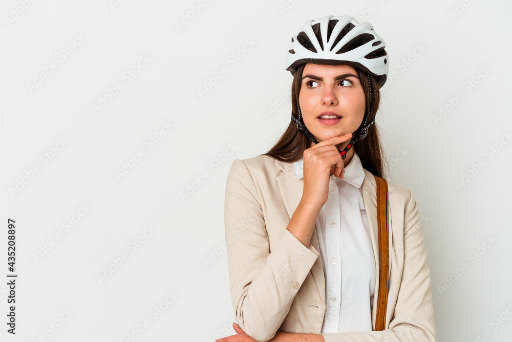 Young caucasian woman riding a bicycle to work isolated on white background looking sideways with doubtful and skeptical expression. Young caucasian woman riding a bicycle to work isolated on white background looking sideways with doubtful and skeptical expression.